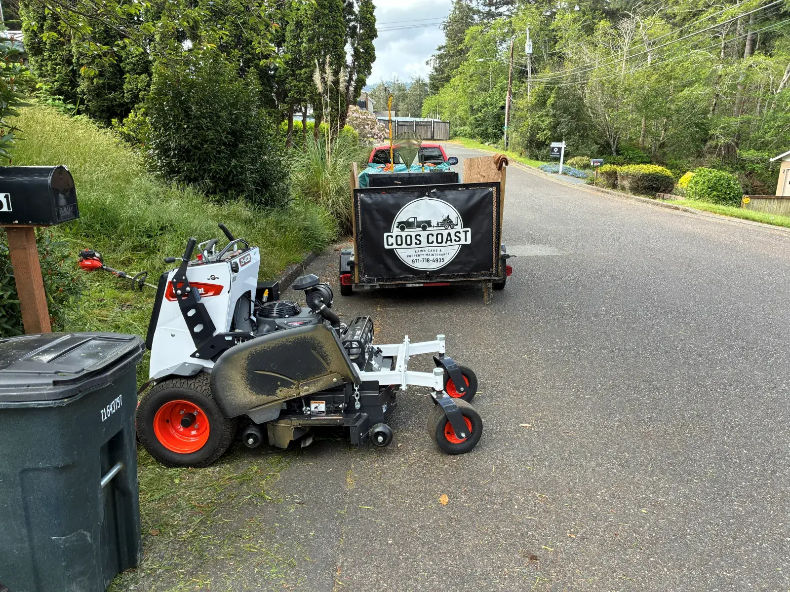 Coos Coast Cleanup walk-behind mower and branded trailer on a Coos County street