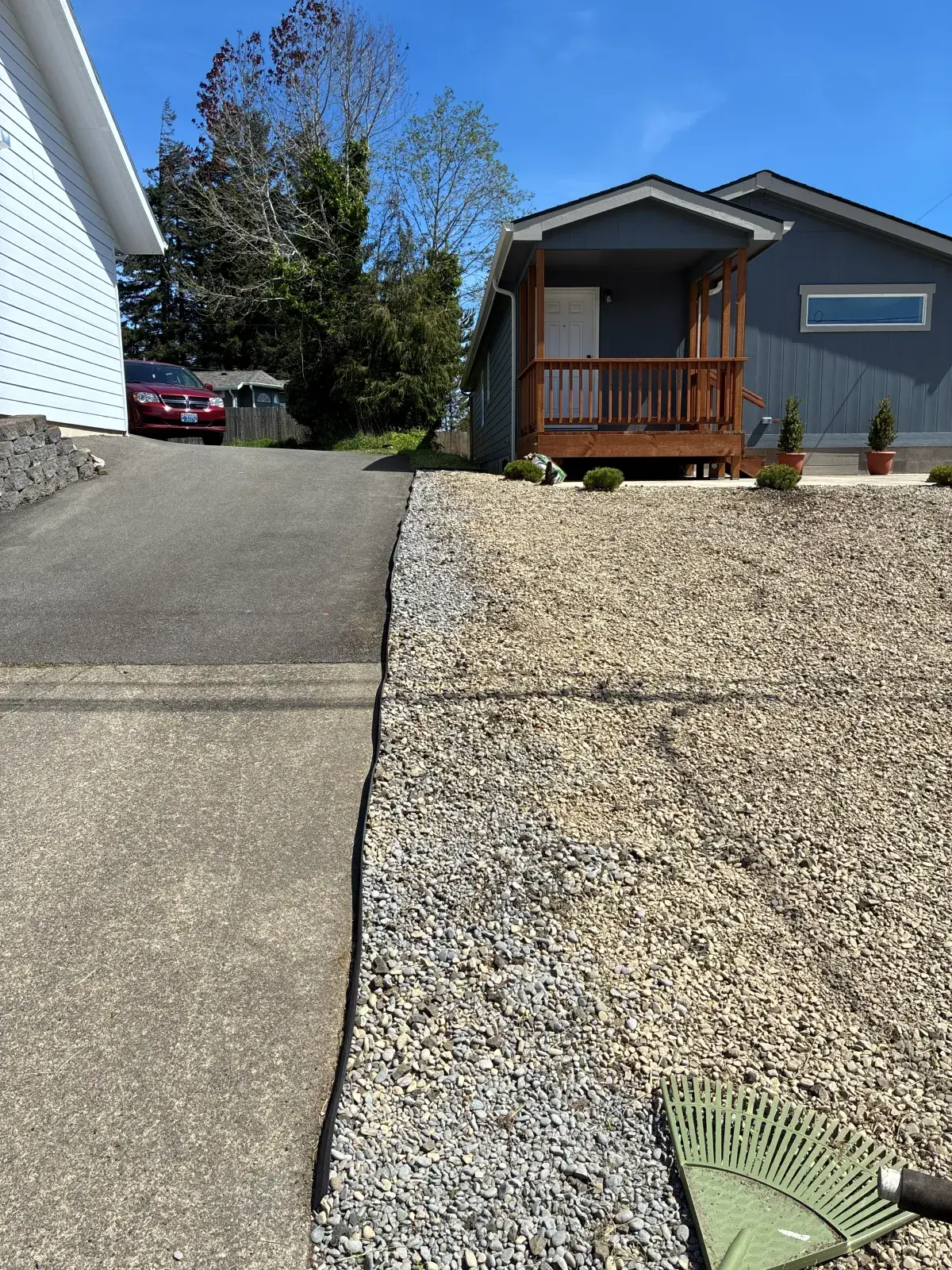 Fresh gravel and rock landscaping installed around a Coos County home